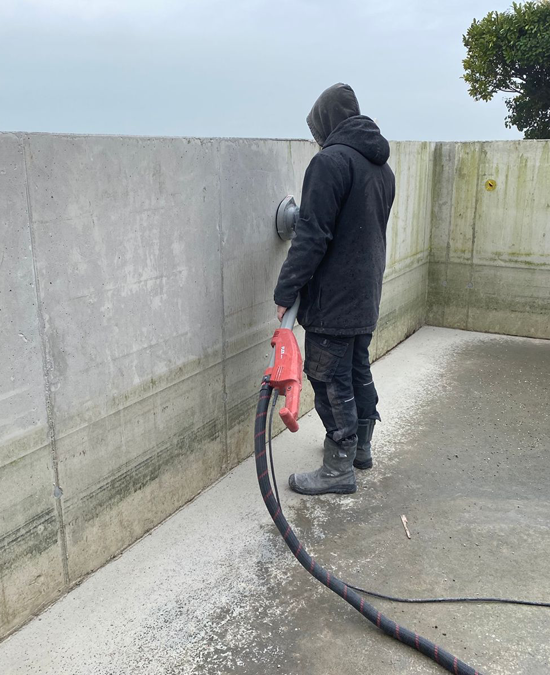 Betonwanden schuren - vloeistof dichtmaken van een betonnen zwembad wand