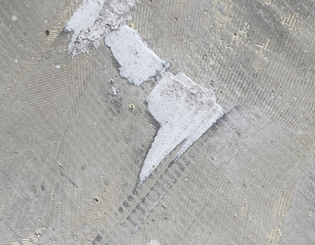 Lijmresten van betonvloer schuren en verwijderen