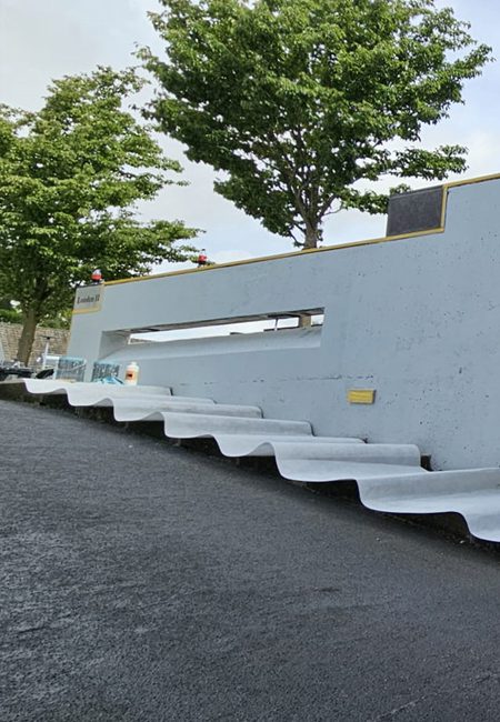 Afgewerkte lichtgrijze betonwand langs hellingbaan van VvE in Hoofddorp