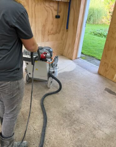 Medewerker schuurt en egaliseert betonvloer in Spanbroek