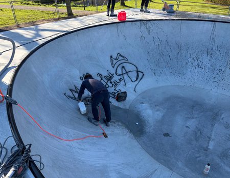 Medewerker verwijdert graffiti uit betonnen bowl in skatepark Alphen aan den Rijn
